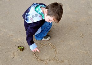 "a boy playing on the seashore"